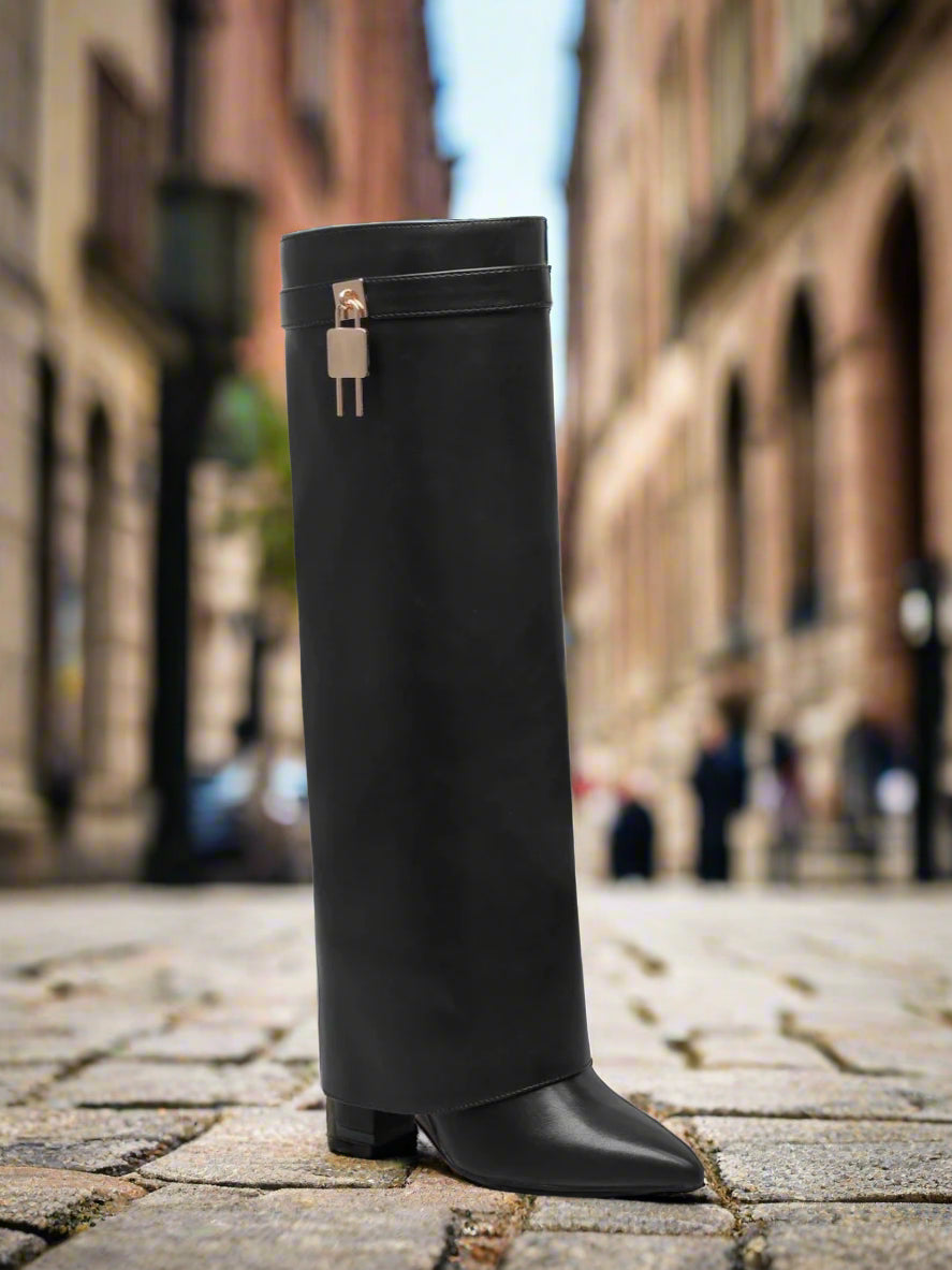 Black knee-high boot with a gold buckle on a white background