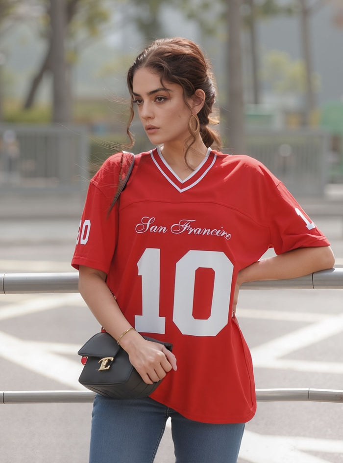 Woman wearing a red 'San Francisco' jersey with the number 10, holding a black handbag.