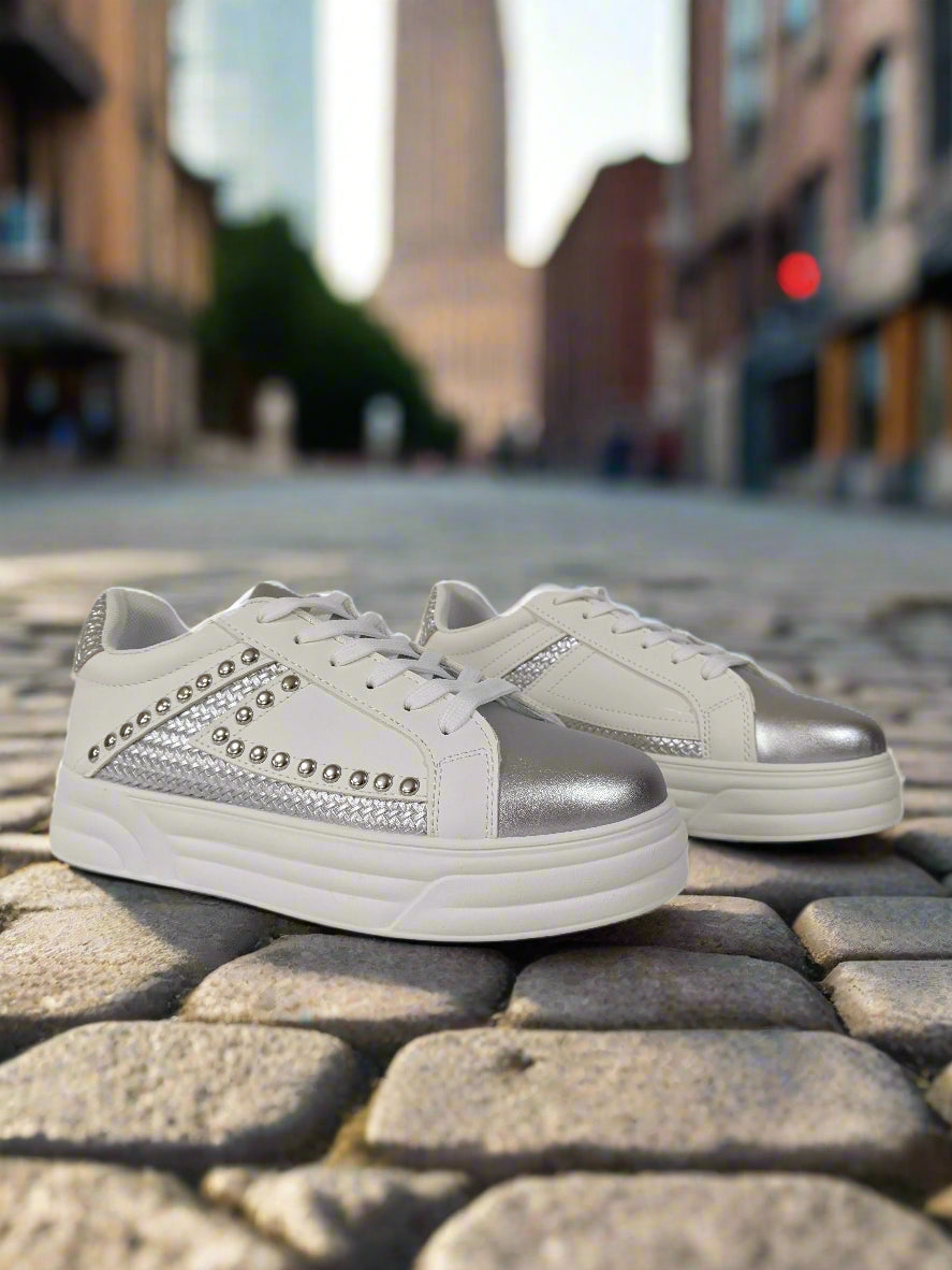 White sneakers with silver accents on a white background