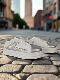 White sneakers with silver accents on a white background